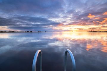 Ein ruhiger Sonnenuntergang über dem Leekstermeer in Groningen. Die glatte Oberfläche des Wassers gi von Bas Meelker