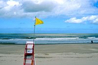 Gelbe Strandflagge zum Rettungsschwimmerstuhl