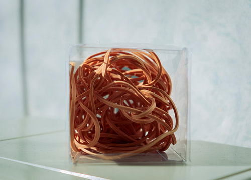 Rubber bands formed in box with beautiful gray / white wallpaper behind
