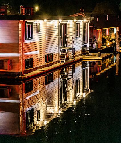 Woonark met verlichting en spiegeling bij nacht