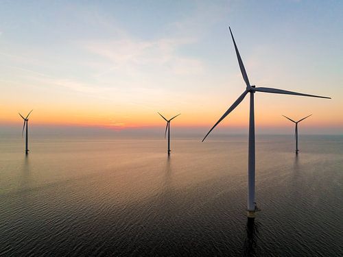 Windturbines in een offshore windpark tijdens zonsondergang