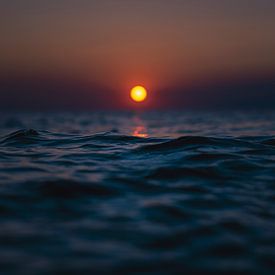 Le soleil rouge s'enfonce dans la mer bleue sur Florian Kunde