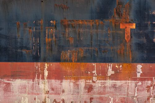 Roest sporen langs de scheepsromp van een vrachtschip.