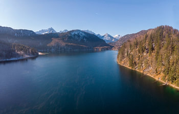 Aerial view of Alpsee with mountains and forests