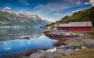 rote häuser und ein boot auf dem fjord in norwegen