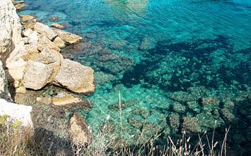 Rotsenpartij met azuurblauw water in Puglia, Italie van Bianca ter Riet