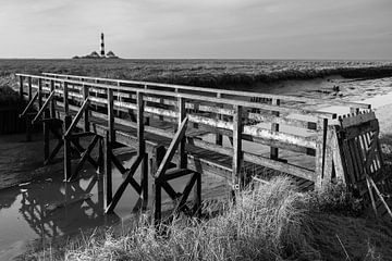 Lighthouse Westerheversand with small bridge in the salt marshes - black and white
