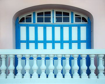 Een blauw balkon bij een blauw raam