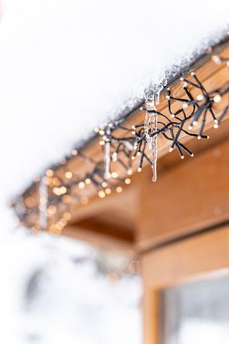 Winter ijspegels met feeënlichtjes in de sneeuw