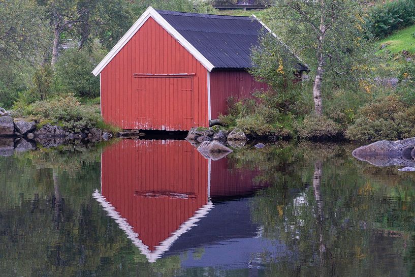 Verspiegeltes Holzbootshaus auf einem See in Norwegen von Henk Alblas
