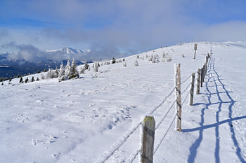 Winter Berglandschaft im Lachtal, Steiermark, mit einem Zaun, der in die Ferne führt