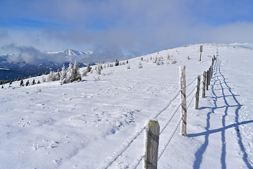 Winter Berglandschaft im Lachtal, Steiermark, mit einem Zaun, der in die Ferne führt