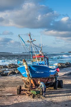 Visser aan t werk bij zijn boot in het avondlicht in de kleine haven van La Santa, Lanzarote.