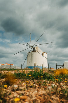 A Mediterranean windmill under a cloudy sky