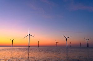 Windturbinen in einem Offshore-Windpark bei Sonnenuntergang