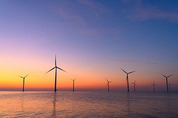Windmolens in een offshore windpark tijdens zonsondergang