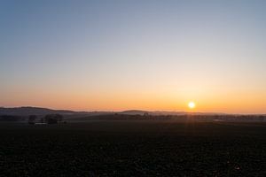 Ruhiger Sonnenuntergang über sanften Hügeln