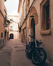 Motor in de traditionele straatjes van het historische Spaanse dorpje Pollença op Mallorca van Michiel Dros thumbnail