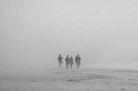 Familie op het strand in de mist