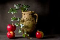 Stilleven van verweerde kruik met appels en klimop