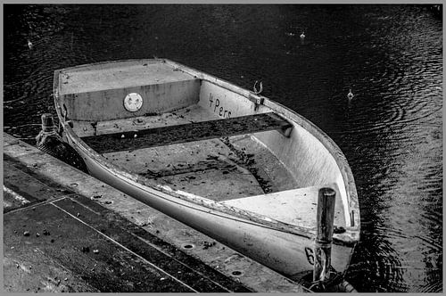 een oude roeiboot in de regen