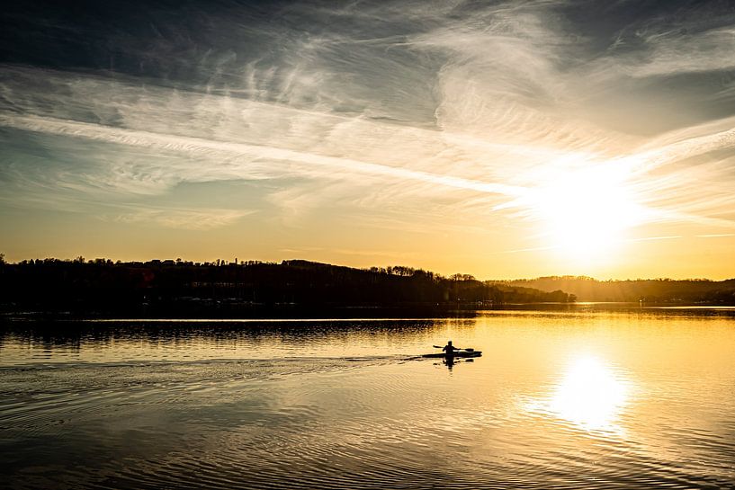 Baldeneysee in Essen with rowers in winter against the light at sunset by Dieter Walther