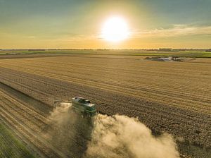Combine oogst tarwe tijdens zomerse zonsondergang van Sjoerd van der Wal Fotografie
