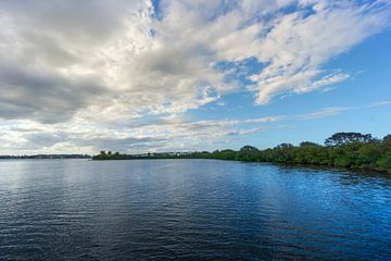 USA, Florida, Uferpromenade mit grünen Bäumen und Pflanzen dahinter und Brücke mit Verkehr von adventure-photos