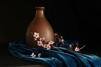 Nature morte fleur de cerisier à côté d'un vase en cuivre