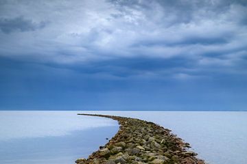 Stormwolken boven een dam in het IJsselmeer