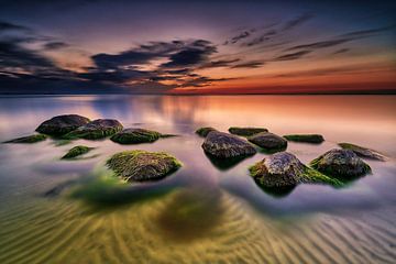 Stenen op de oever in het heldere water van de Oostzee in de avond van Stefan Dinse