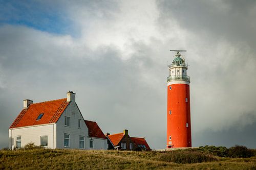 Red lighthouse at the little isle of Texel, the Netherlands with small  old red and white houses