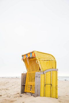 Gele strandstoel in Egmond aan Zee van Angeline Dobber