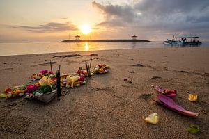 Der Sandstrand von Sanur auf Bali mit Opfergaben im Sonnenaufgang