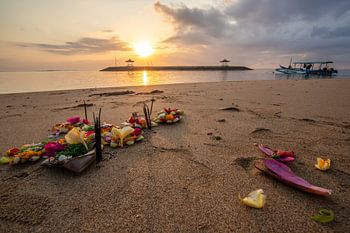 Het zandstrand van Sanur op Bali met offers bij zonsopgang