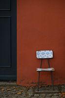 Vintage chair with characteristic Portuguese blue and white tile pattern in front of a red wall in Monchique Portugal