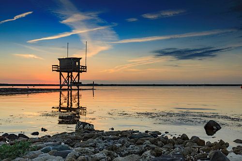 prachtige zonsondergang achter een vissershuisje aan het water in Scharendijke in de provincie Zeela