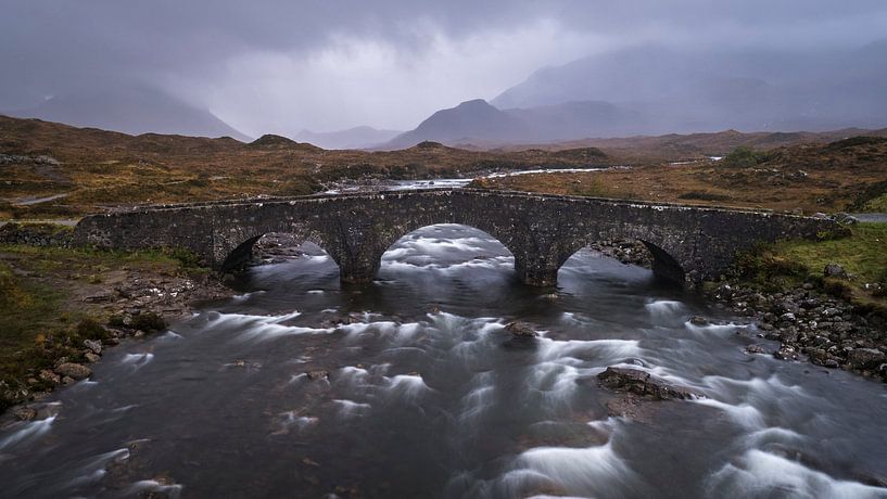 Panorama einer alten Brücke, ein wilder Fluss und Berge im Hintergrund auf der Insel Skye in Schottl von Ralph Rozema