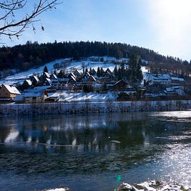 Kleines Dorf im Winter an einem zugefrorenen See von creativcontent