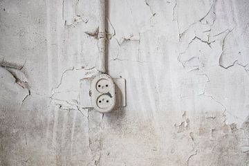 Ouderwets stopcontact aan een beschadigde muur in een verlaten schoolgebouw van Sjoerd van der Wal Fotografie