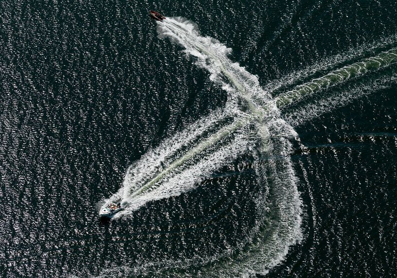 Speedbootjes op het grevelingenmeer kruisen elkaar met hoge snelheid en kruisen elkaars hekgolf. van Sky Pictures Fotografie