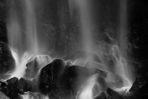 Rasselnder Wasserfall auf Steinfelsen in Schwarz-Weiß