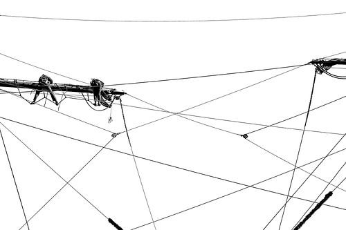 Twee matrozen hangen in de ra van een schip tussen alle touwen. Wout Kok One2expose