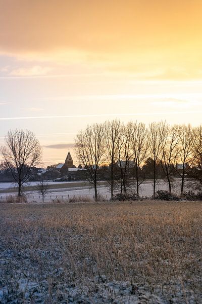 Gouden ochtend in een winters landschap met kerk en sneeuw van Mickéle Godderis