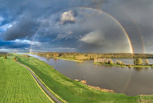 Regenboog tijdens een herfstbui boven de IJssel