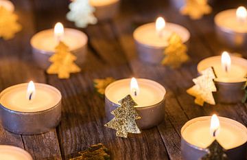 Festlicher Kerzenschein mit Weihnachtsdekoration auf Holztisch von Alex Winter