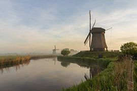 Moulins sur le Molendijk à Schermerhorn lors d'un lever de soleil brumeux sur Bram Lubbers