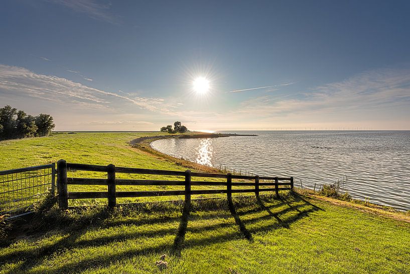 The IJsselmeer dike near the Frisian town of Molkwerum in the afternoon sun by Harrie Muis