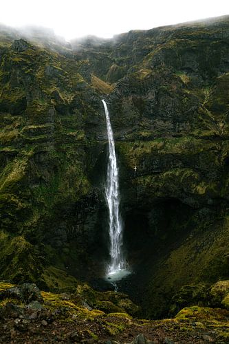 IJslandse waterval in een groen, met mos bedekt landschap