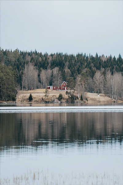 Red house on small hill by a lake in Zweden by Joep van de Zandt